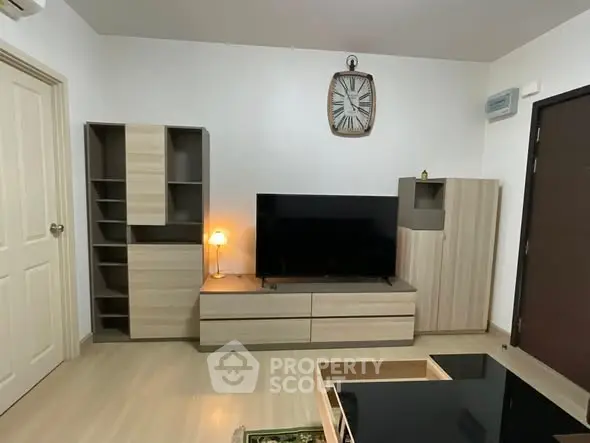Modern living room with sleek wooden furniture and large TV setup.