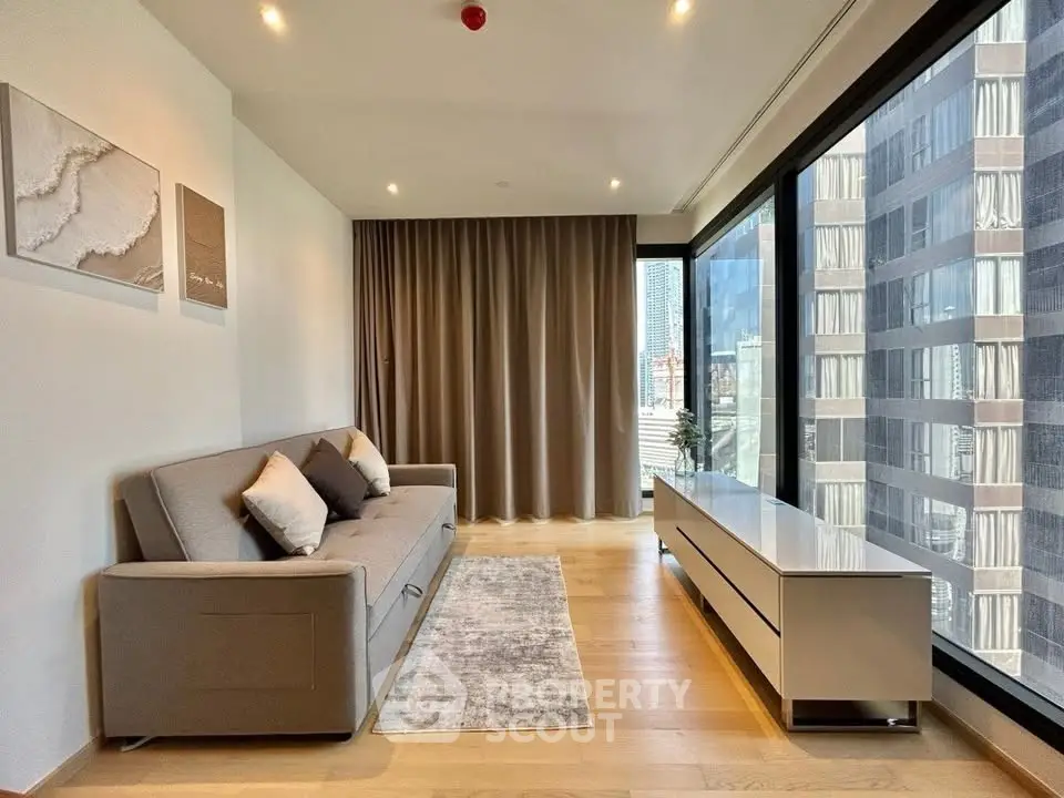 Modern living room with large windows and city view, featuring a sleek sofa and minimalist decor.