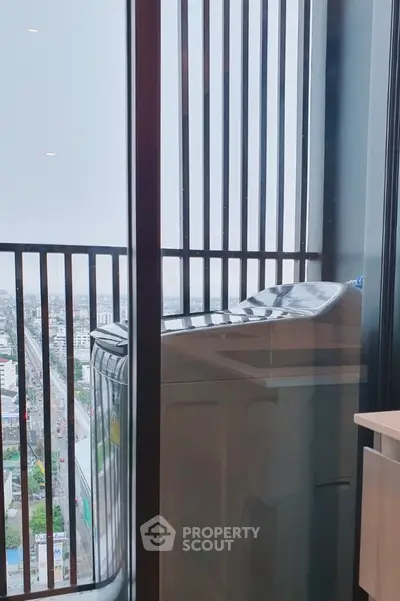 High-rise apartment balcony with washing machine and city view