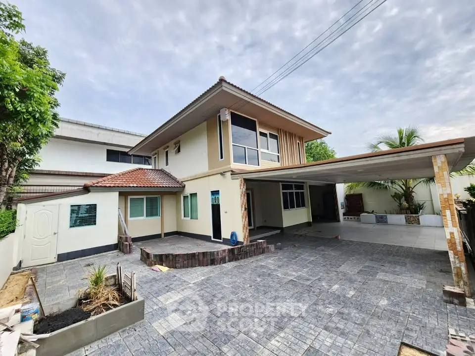 Spacious modern two-story house with large driveway and carport, perfect for family living.