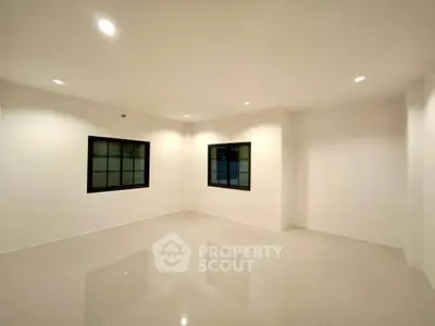 Spacious empty room with glossy tiled floor and recessed lighting, perfect for customization.