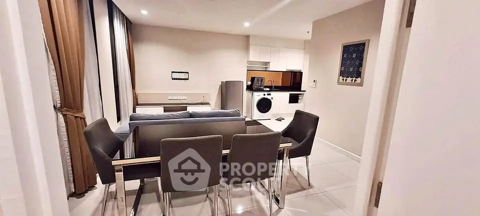Modern open-plan living room with dining area and kitchen appliances