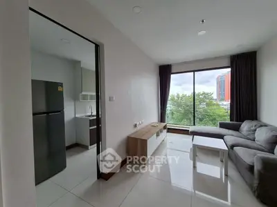 Modern living room with large window and adjacent kitchen in urban apartment