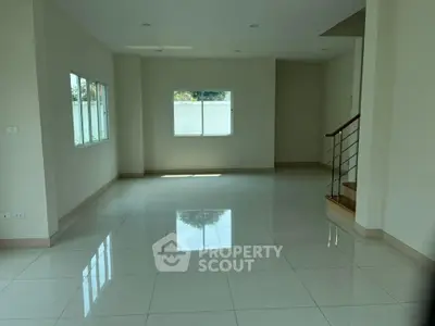 Spacious empty living room with large windows and glossy tiled floors, perfect for customization.