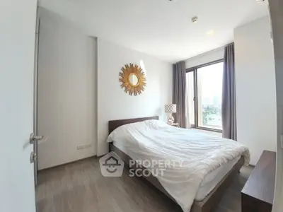 Bright and cozy bedroom with large window and stylish decor in modern apartment.