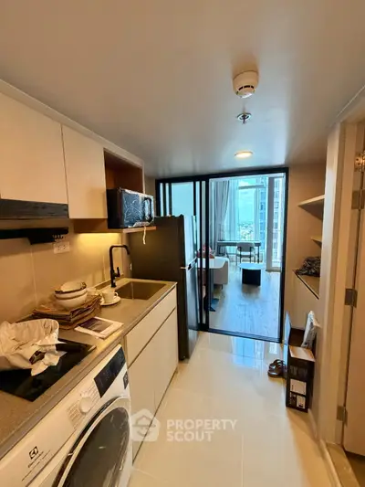 Modern kitchen with open layout leading to a bright living area with city view.