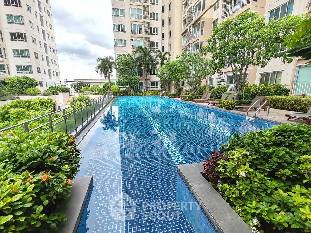 Luxurious apartment complex with a stunning outdoor pool surrounded by lush greenery.