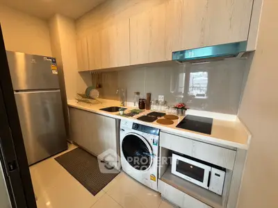 Modern kitchen with sleek cabinetry, built-in appliances, and a washing machine for convenient living.