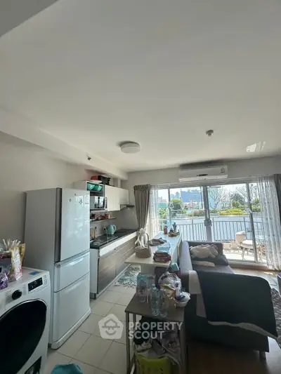 Spacious living room with open kitchen and balcony view