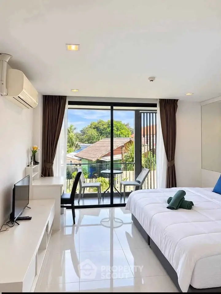 Bright modern bedroom with balcony and scenic view, featuring sleek furniture and large windows.