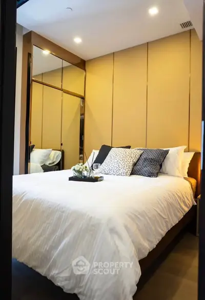 Luxurious bedroom with elegant decor and cozy ambiance, featuring plush bedding and stylish lighting.