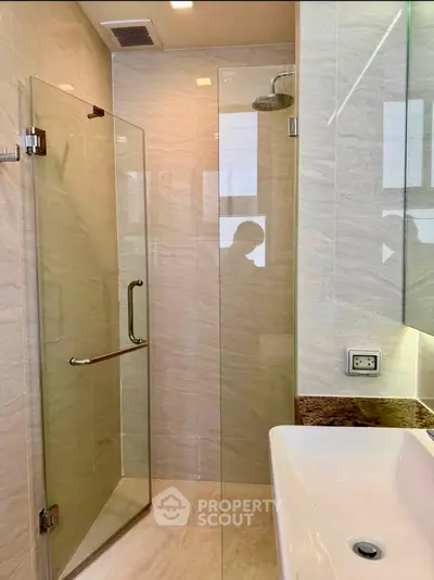 Modern bathroom with glass shower enclosure and sleek sink design
