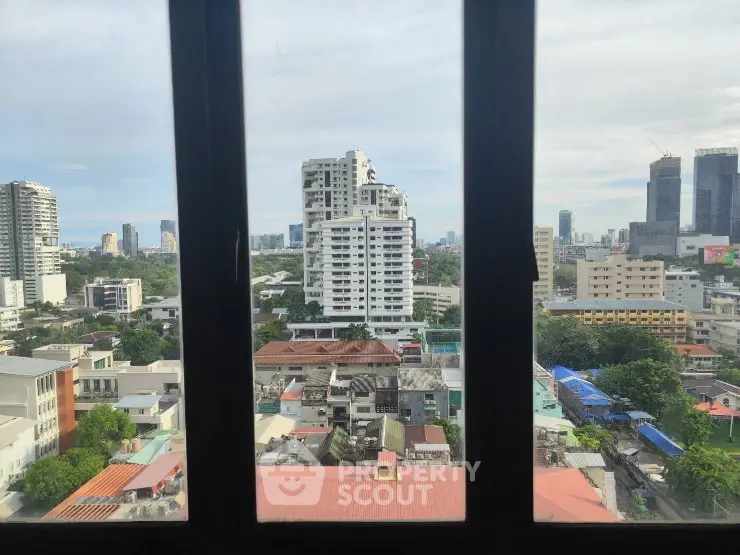 Stunning cityscape view from high-rise window showcasing urban skyline and greenery.