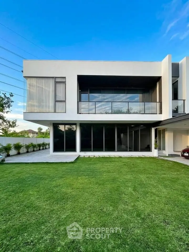 Modern luxury home with sleek architecture and spacious green lawn, perfect for contemporary living.