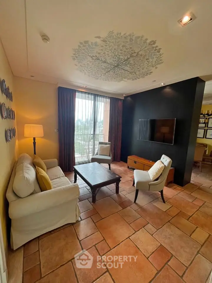 Charming living room with elegant decor and natural light, featuring cozy seating and a wall-mounted TV.