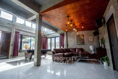 Spacious modern living room with industrial design, featuring large windows and stylish lighting.