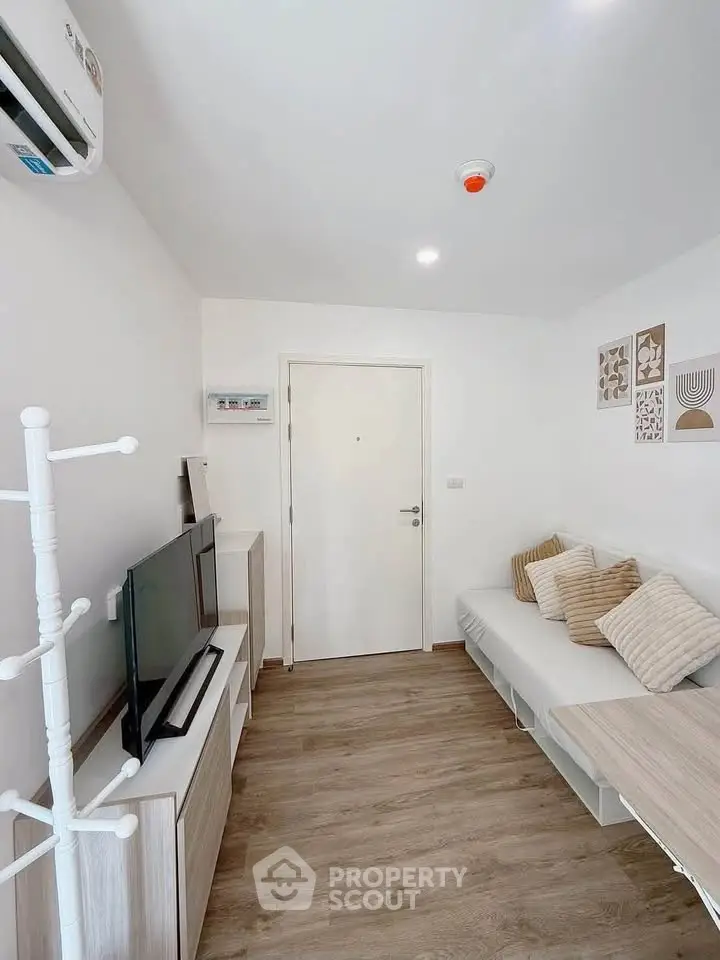 Modern living room with sleek furniture and wooden flooring, perfect for cozy gatherings.