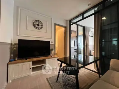 Modern living room with stylish decor and glass partition leading to kitchen area.