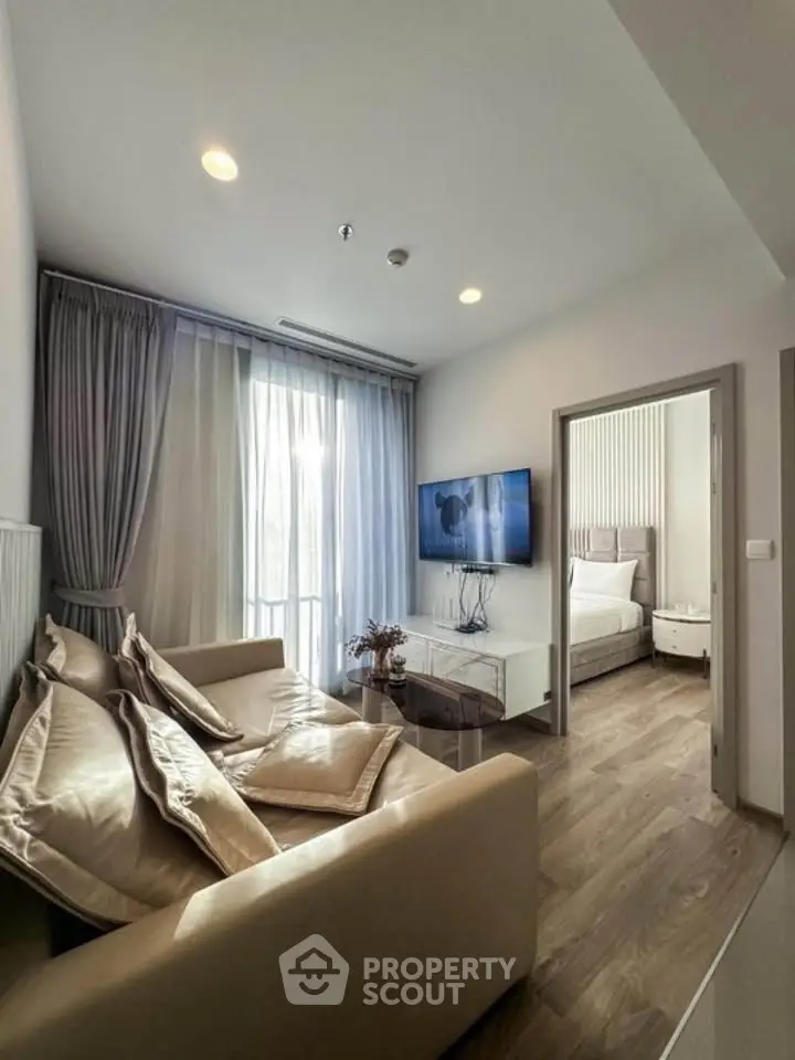 Modern living room with elegant decor and cozy seating, adjacent to a stylish bedroom, perfect for urban living.