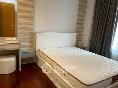 Cozy bedroom with wooden flooring and natural light