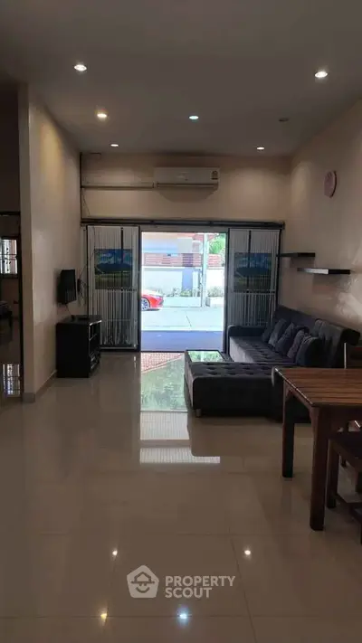 Spacious living room with modern furniture and large window offering natural light.