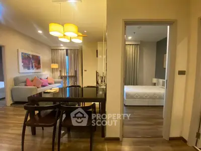Spacious modern apartment with open living and dining area, featuring elegant lighting and cozy furnishings.