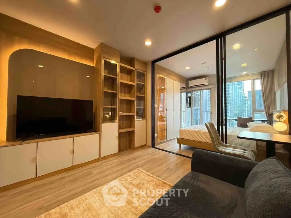Modern living room with open layout, stylish furniture, and city view from balcony.