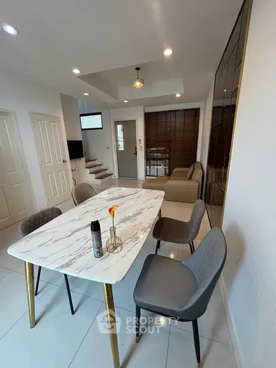 Modern dining area with marble table and stylish chairs in a contemporary home interior.