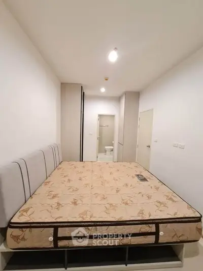 Spacious bedroom with modern design and comfortable mattress, perfect for relaxation and rest.