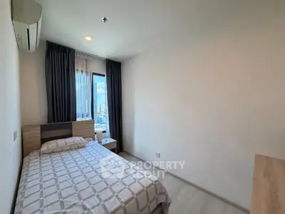 Cozy bedroom with city view, featuring modern furnishings and ample natural light.