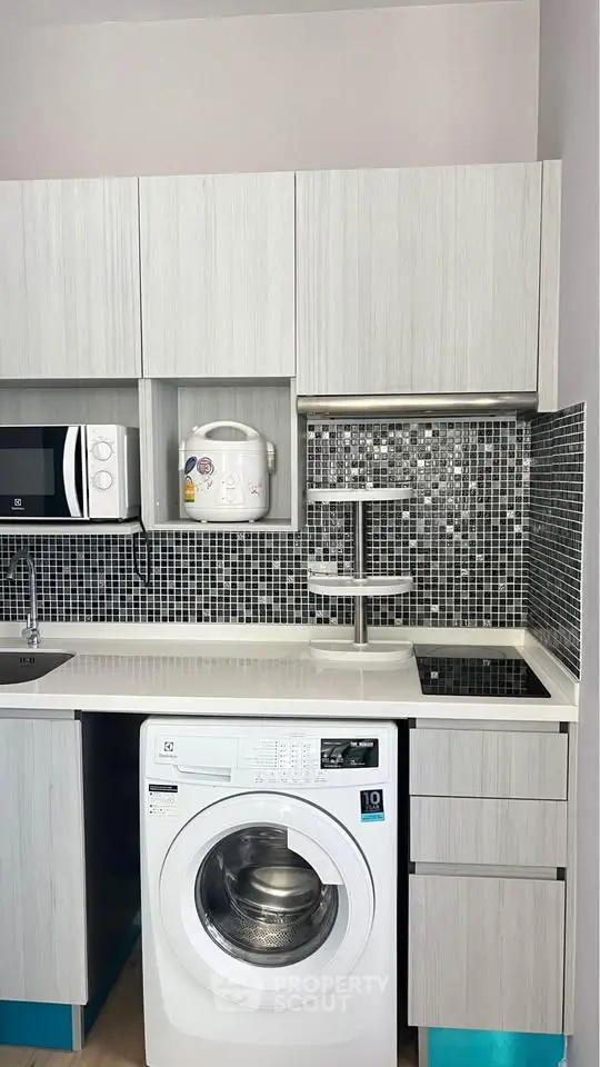 Modern compact kitchen with washing machine and sleek cabinetry