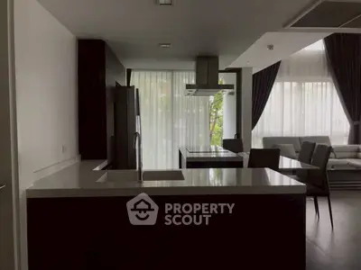 Modern kitchen with sleek design and open layout, featuring a central island and dining area.