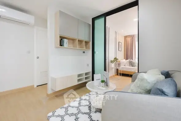 Modern living room with stylish decor and open layout leading to bedroom.