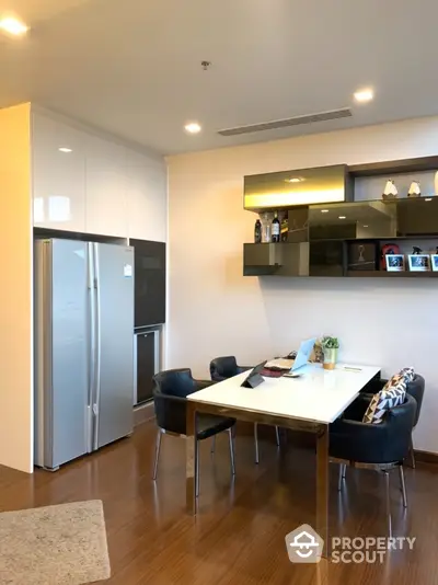 Modern kitchen with sleek dining area and stylish shelving in a contemporary apartment.