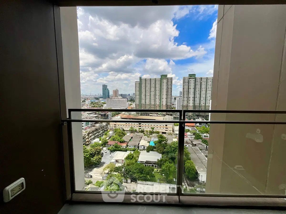 Stunning cityscape view from a high-rise balcony with clear blue skies.