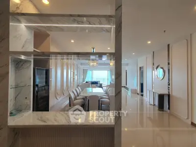 Luxurious open-plan living room with elegant marble accents and modern furnishings.