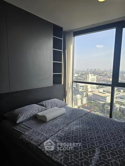 Modern bedroom with large window offering stunning city view, perfect for urban living.