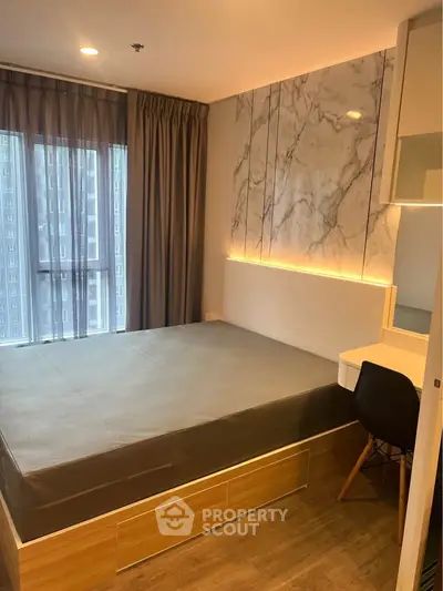 Modern bedroom with stylish marble accent wall and large window view.