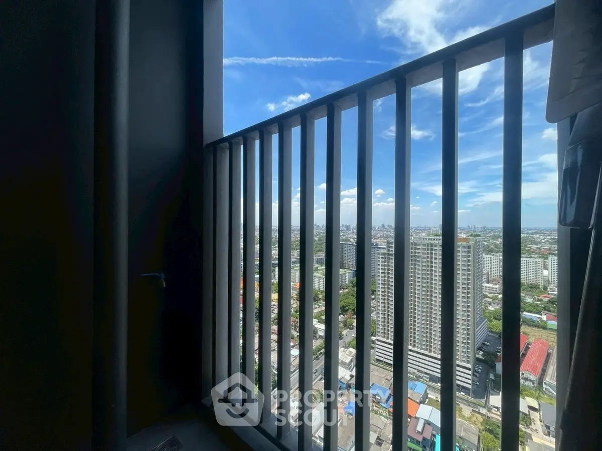 Stunning high-rise balcony view showcasing city skyline and blue sky.