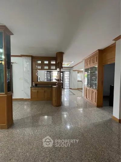 Spacious open-plan living area with elegant wooden cabinetry and polished flooring.