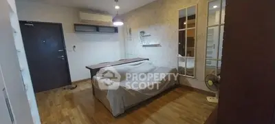 Cozy living room with wooden flooring, air conditioning, and stylish wall mirrors.