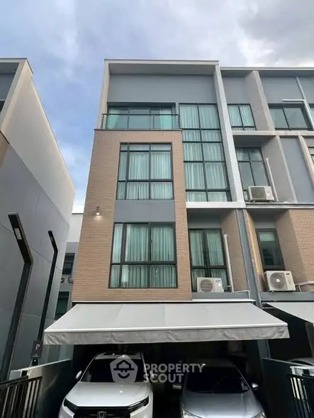 Modern multi-story townhouse with carport and large windows