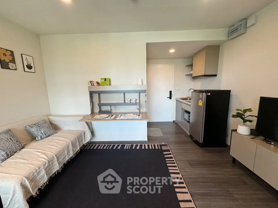 Modern living room with cozy sofa, stylish kitchen, and sleek appliances in open layout apartment.