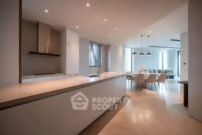 Luxurious open-plan kitchen and dining area with modern design and elegant lighting.