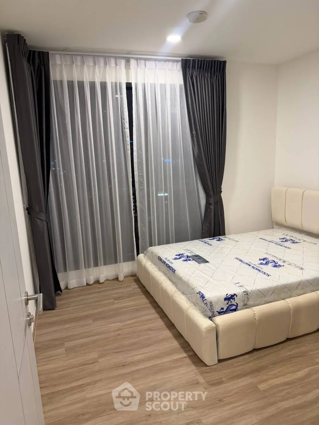 Modern bedroom with elegant curtains and stylish bed in a cozy apartment.
