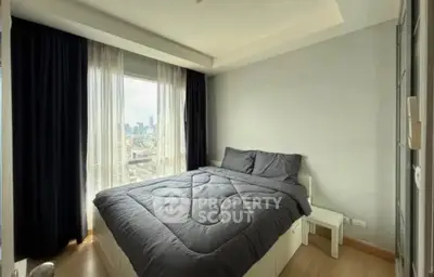Cozy bedroom with city view, featuring modern decor and ample natural light.