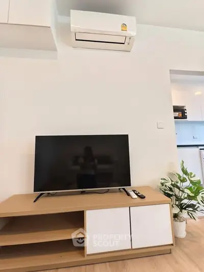 Modern living room with sleek TV setup and air conditioning unit, showcasing minimalist design.
