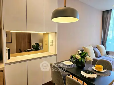 Modern dining area with elegant lighting and cozy living room view