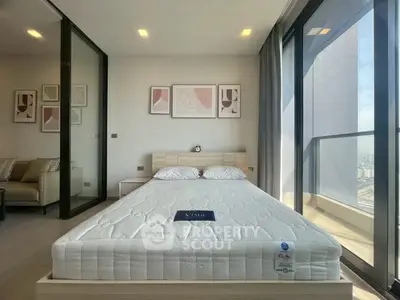 Modern bedroom with large windows and city view, featuring stylish decor and comfortable bedding.