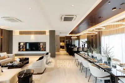 Luxurious open-plan living and dining area with modern decor and elegant lighting.